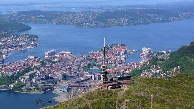 Beautiful drone shot from Mount Ulriken in Bergen, Norway with amazing views of the city centre and the fjord. You can see the gondola arriving at the station.