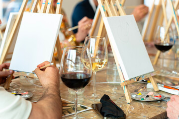 Sip and Paint Event. Group of friends painting and drinking wine