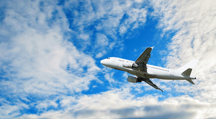 Travel background with airplane flying in the blue sky