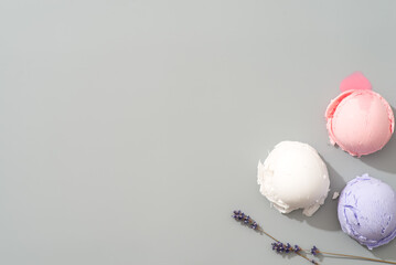 Three scoops of ice cream in different colors placed on a gray surface
