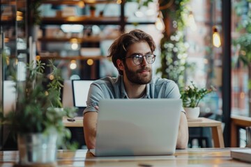 Obraz premium Young Businessman using laptop computer and Thinks about successful ideas in modern office.