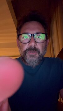 Camera view of adult man with doubts about join or not in a fake website page. Concept of fraud and money transfer or payment online. One mature person in front of the smartphone app clicking worried