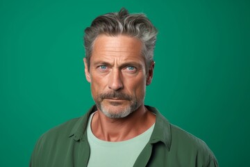 Obraz premium Man with a seductive expression, aged 45 and older, against a light green backdrop