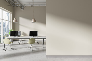 Beige coworking interior with pc desktop and armchairs near window. Mockup wall