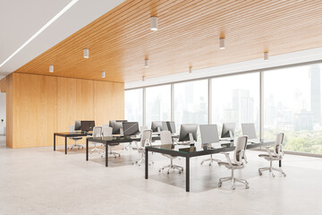 Modern open office space with computers on desks, contemporary style, large city-view windows, concept of corporate work environment.  3D Rendering