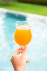 Young woman in bikini and hat in swimsuit laying on chaise-longue and sunbathing by the pool in a summer vacation