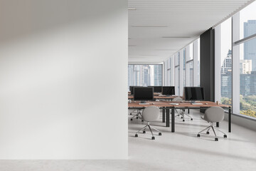 White coworking interior with table and pc monitors, window. Mockup wall