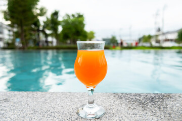 Young woman in bikini and hat in swimsuit laying on chaise-longue and sunbathing by the pool in a summer vacation