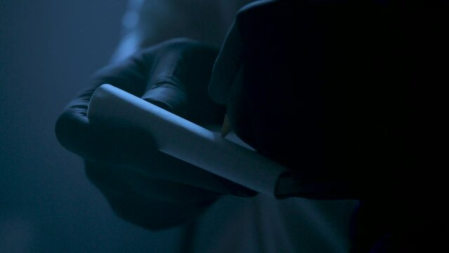 Police Inspector Writes on Notebook with Black Gloves
