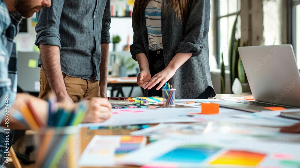 Poster image showcasing a team of professionals collaborating on a design project with plans and color samp