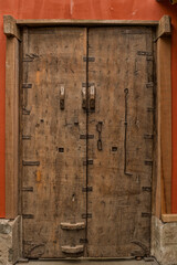 Wooden door on an orange wall building entrance