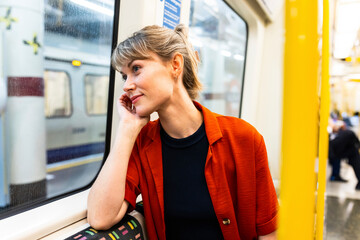 Young woman sitting in train and daydreaming
