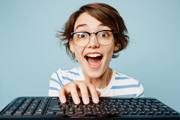 Close up young surprised geek nerd smart woman wear striped t-shirt casual clothes glasses typing...