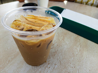 Cold iced coffee served in a plastic cup