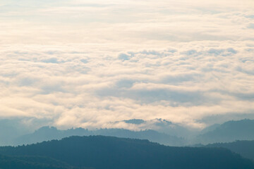 Morning view over white puffy clouds with blue sky on horizon.