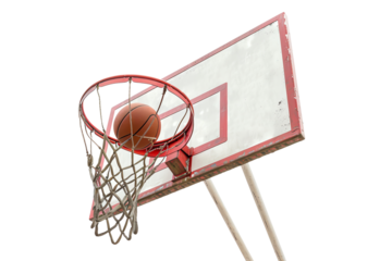 A basketball successfully going through the hoop attached to a weathered backboard, capturing the moment of scoring in a game or practice session.
