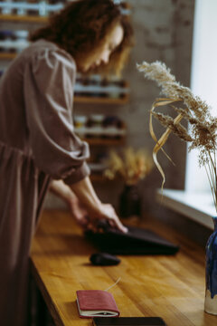 Businesswoman opening laptop on desk in workshop