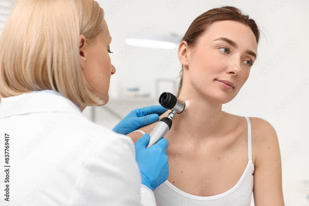 Canvas Prints dermatologist with dermatoscope examining patient in clinic