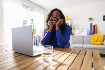 Happy freelancer leaning on elbows and sitting at home