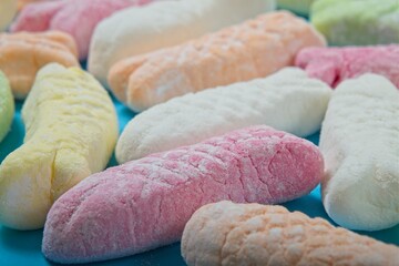 Marshmallows in the shape of little fish on a blue background
