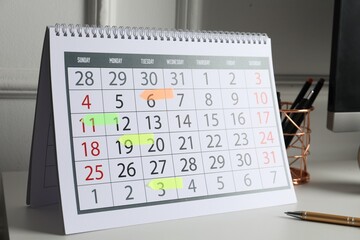 Timetable. Calendar with marked dates and stationery on white table indoors