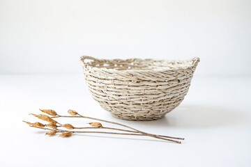 Wicker Basket with Dried Branch on White Background