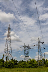High-voltage power lines and towering electrical pylons cutting across the landscape. A striking contrast between technology and nature, symbolizing energy, connectivity, and modern infrastructure.