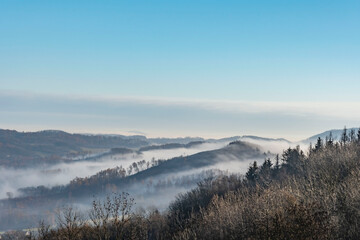 view from a hill in Ceske Stredohori with blue sky and fog