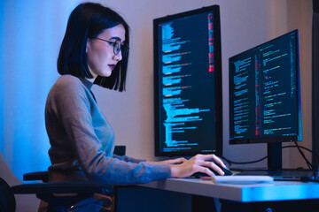 Asian woman  software development working on coding  computer screen and flowchart at night in...