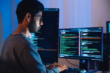 Indian software development working on coding  computer screen and flowchart at night in modern...