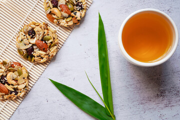 top view of a cup of hot chinese tea and dessert made from grains with green leaves