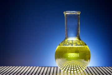 Erlenmeyer glass flask placed in a laboratory table with yellow liquid