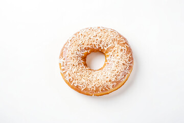 Close up of a coconut glazed donut on a white background