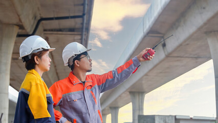 Asian engineering team Inspecting construction work radio command concrete road bridge highway
