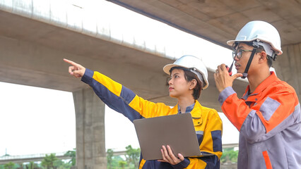 Asian male and female engineers Inspecting construction work radio command concrete road bridge...