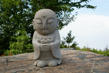 A stone statue of jizo in the Japanese garden.