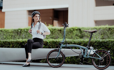 Eco friendly, businesswoman ride bicycle in urban to reduce carbon footprint. Beautiful woman environment conservation person commuting with bicycling. Cycling, alternative transport for green energy.