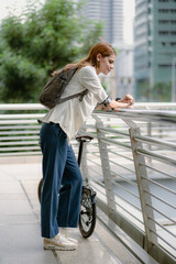 Eco friendly, businesswoman ride bicycle in urban to reduce carbon footprint. Beautiful woman environment conservation person commuting with bicycling. Cycling, alternative transport for green energy.