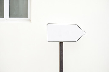 Blank White Arrow Sign on a White Wall