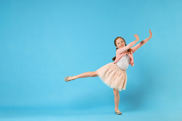 Obraz premium Cute little girl dancing on light blue background, space for text