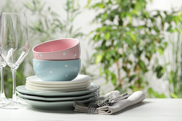 Beautiful ceramic dishware, glasses and cutlery on white marble table outdoors