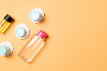 Set of travel size cosmetic bottles on colored background. Flat lay of cream jars. Top view of bodycare style concept