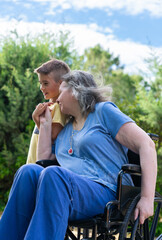 Grandmother in a wheelchair with her grandson pampering each other