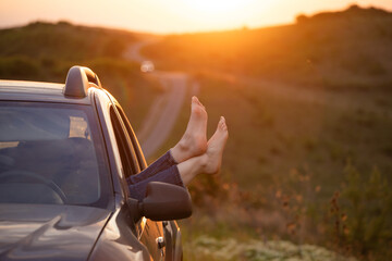 Summer travel concept with legs of a woman and car.