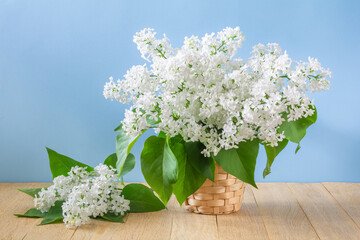 Bouquet of white lilac flowers in a wicker basket