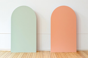 A pastel green and pastel orange half arch-shaped panel two panels, minimalist, simple, white background, flat. light wood flooring
