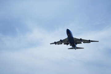 Airplane is flying in the sky with the landing gear down