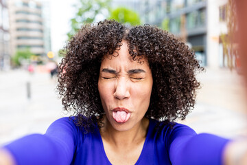 Fototapeta premium Curly woman taking a funny selfie