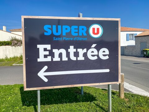 Super U entrance sign outside the parking lot of the supermarket