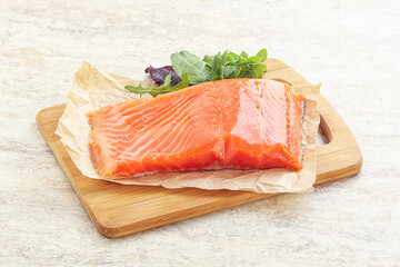Raw salmon fillet over board